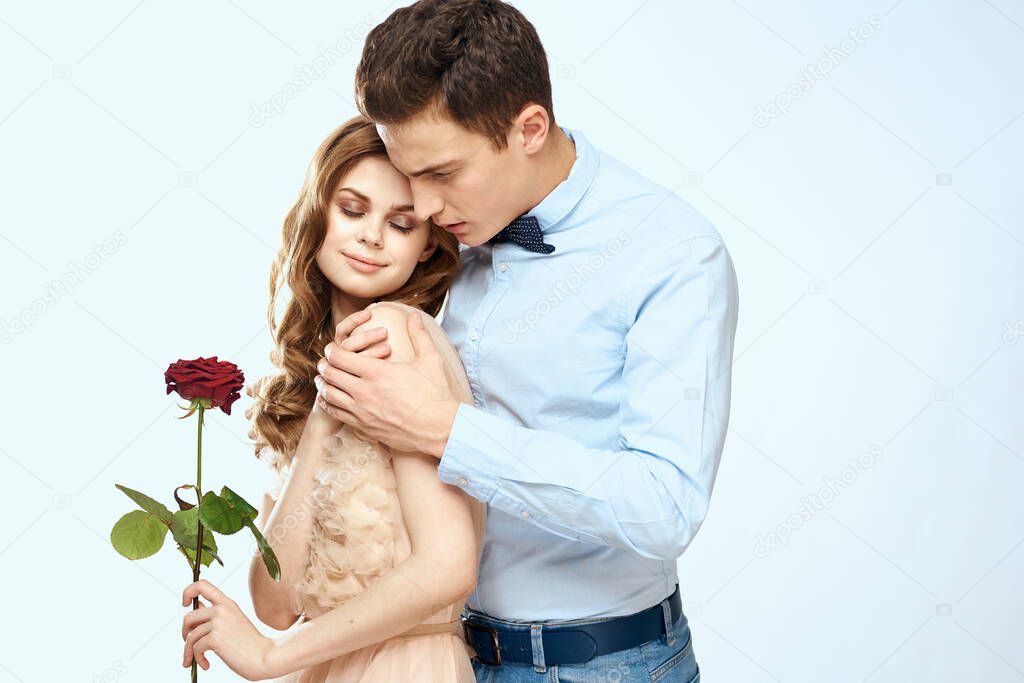 Young couple hugs romance dating lifestyle relationship light background red rose