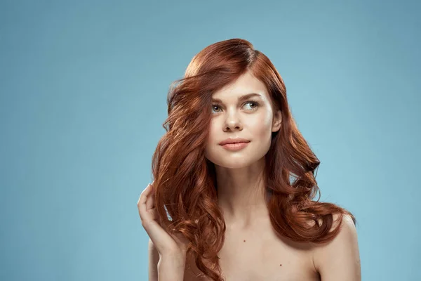 Schöne Frau lockiges langes Haar glatte Frisur nackte Schultern Kosmetik Pflege blauer Hintergrund — Stockfoto
