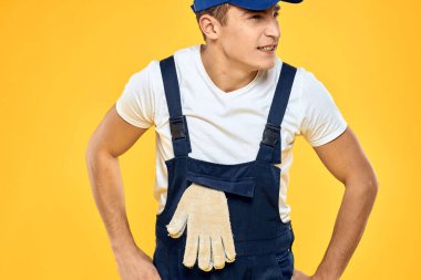 Eldivenli işçi üniforması içinde servis sarı arka planda.
