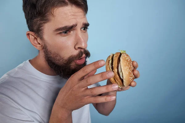 Emotionale Mann Hamburger Fast Food Diät Nahrung Nahaufnahme blauer Hintergrund — Stockfoto