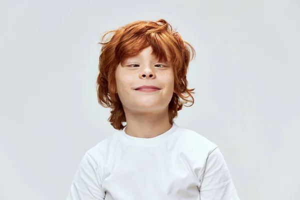 Glasögonorm rödhårig pojke skelande ögon beskärd vy och vit t-shirt — Stockfoto