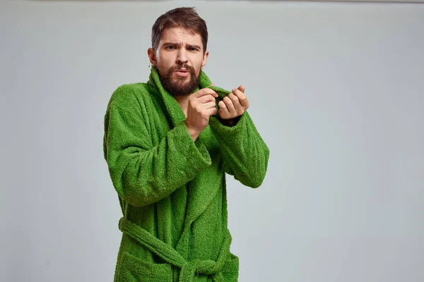 Vista close-up de um homem barbudo em um manto verde em um fundo claro vista cortada — Fotografia de Stock