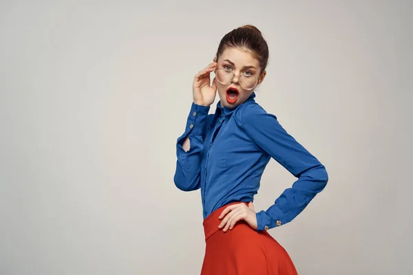 Kvinna modell i blå skjorta och röda kjol glasögon vacker ansikte makeup studio — Stockfoto