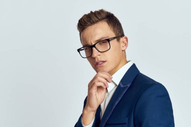 Gözlüklü bir iş adamı mavi takım elbiseli resmi ışık arkaplanı kesmiş.