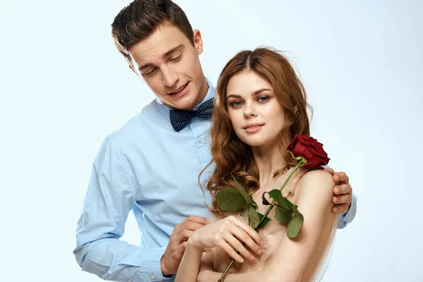 Hombre y mujer con una rosa roja sobre un fondo claro amor abrazos familiares —  Fotos de Stock