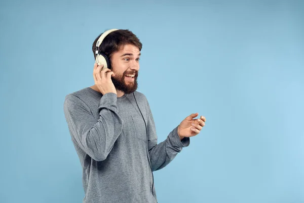 Hombre usando auriculares música emoción estilo de vida moderno estilo tecnología azul fondo — Foto de Stock