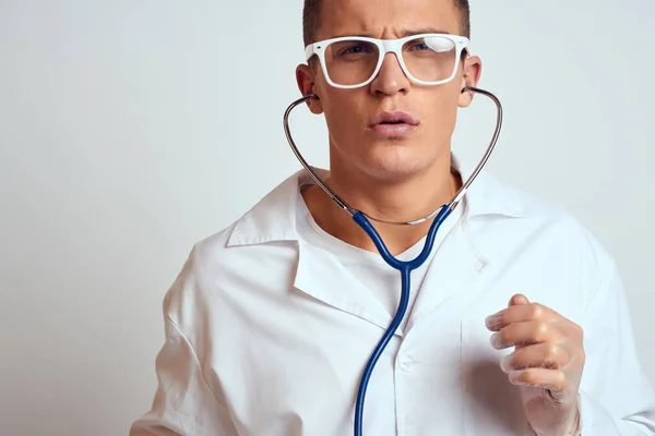 Doctor in a medical gown with a stethoscope and glasses on a light background cropped view portrait — Stock Photo, Image