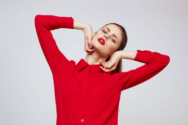 Açık arkaplanda kırmızı dudaklı bir kadının portresi. Makyaj modeli.