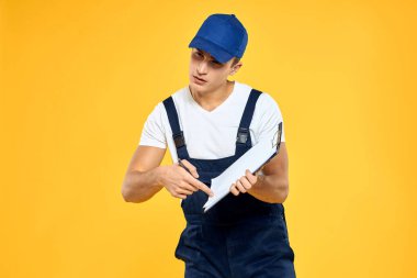 Çalışan üniformalı bir adam servis servisi sarı arka planını sunuyor.