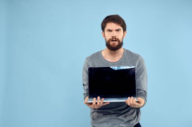 Sakallı adam dizüstü bilgisayarı elinde internet kablosuz teknoloji duyguları mavi arka plan