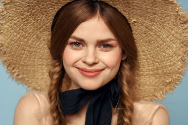 Hasır şapkalı kız portresi yakın çekim at kuyruğu eğlenceli kızıl saçlı mavi arka plan