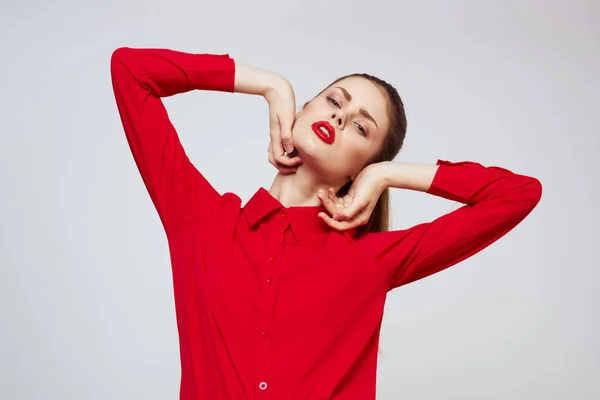 Retrato de una mujer con labios rojos en una camisa sobre un fondo claro recortado ver modelo maquillaje peinado — Foto de Stock