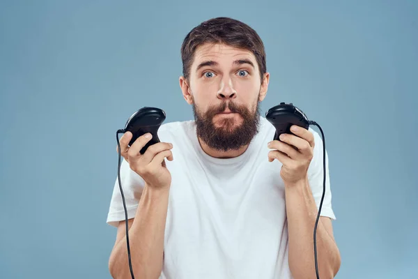 Hombre celebración gamepads juegos estilo de vida tecnología consola emociones blanco camiseta azul fondo —  Fotos de Stock