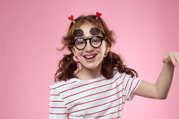 Menina alegre com tranças óculos de sol listrado t-shirt estilo de vida rosa fundo — Fotografia de Stock