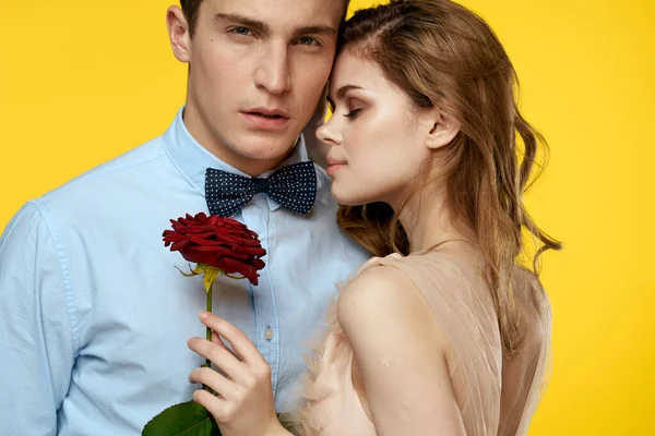 Szerelmes férfi és nő vörös rózsa sárga háttér vágott kilátás közelkép romantika — Stock Fotó