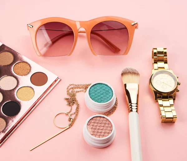 Cosmetics on pink background eyeshadow brush powder blush clock — Stock Photo, Image