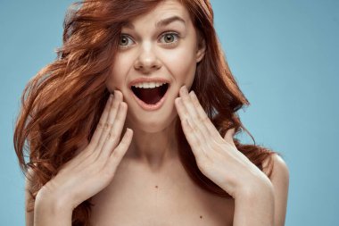 Güzel, kıvırcık saçlı, kıvırcık saçlı, çıplak omuzlu bir kadın.