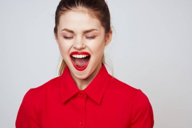 Açık arkaplanda kırmızı dudaklı bir kadının portresi. Makyaj modeli.