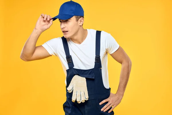 Hombre en uniforme de trabajo emociones prestación de servicio de entrega de fondo amarillo — Foto de Stock