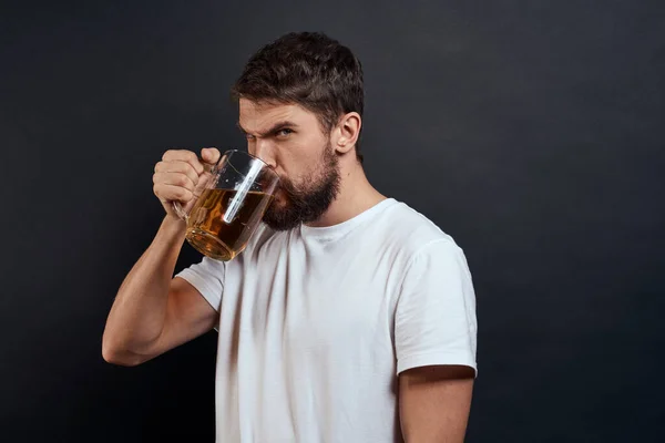 Mann mit einem Becher Bier in der Hand Emotionen Spaß Lifestyle weißes T-Shirt dunkel isoliert Hintergrund — Stockfoto