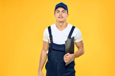 Eldivenli işçi üniforması içinde servis sarı arka planda.