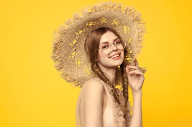 Sarı arka planda saman şapkalı portre kadın. Yazlık elbise mankeni romantizmi.
