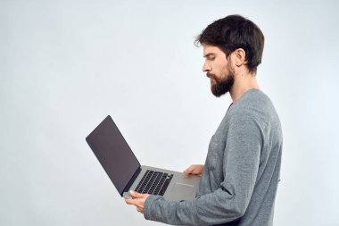 Gri kazaklı bir adam dizüstü bilgisayarlı. Yaşam tarzı teknoloji iletişimi internet işi yapıyor.