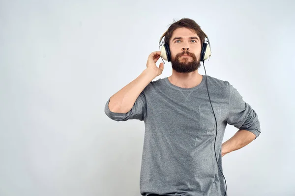 Man in hoofdtelefoon luistert naar muziek levensstijl vrije tijd licht achtergrond — Stockfoto