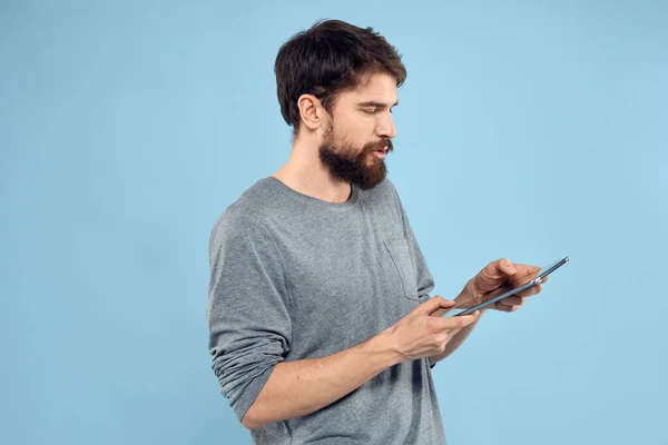 Man met tablet in handen technologie levensstijl draadloos apparaat blauwe achtergrond — Stockfoto