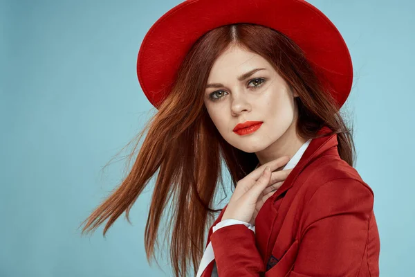 Hermosa mujer en sombrero rojo chaqueta labios rojos pelo largo encanto fondo azul — Foto de Stock