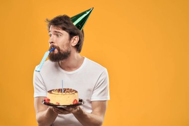 Pasta şapkalı doğum günü çocuğu. Eğlenceli sarı arka plan partisi.