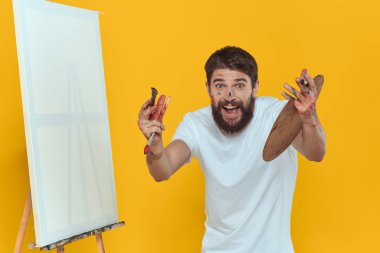 Erkek sanatçı palet resim sehpası hobi yaşam tarzı yaratıcılık sarı arka plan