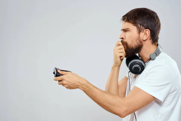 Homme avec casque de gamepad jouant la technologie de loisirs blanc t-shirt fond clair — Photo