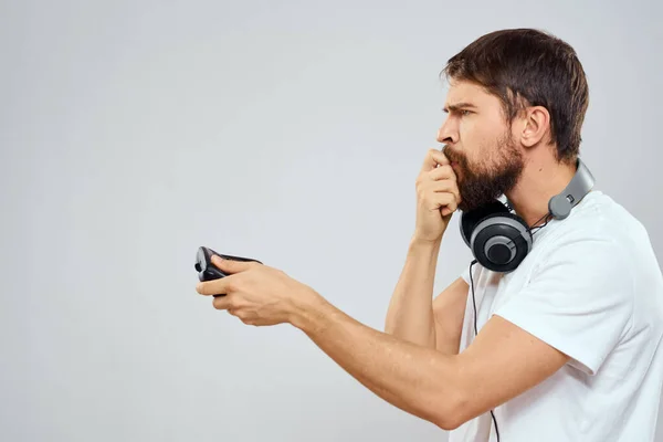 Man met gamepad hoofdtelefoon spelen vrijetijdsbesteding technologie wit t-shirt lichte achtergrond — Stockfoto