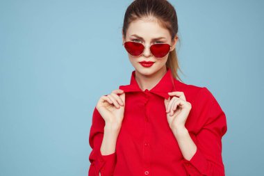 Gözlüklü ve kırmızı dudaklı bir kadının portresi. Mavi arka plan modeli.