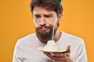 Pasta şapkalı doğum günü çocuğu. Eğlenceli sarı arka plan partisi.