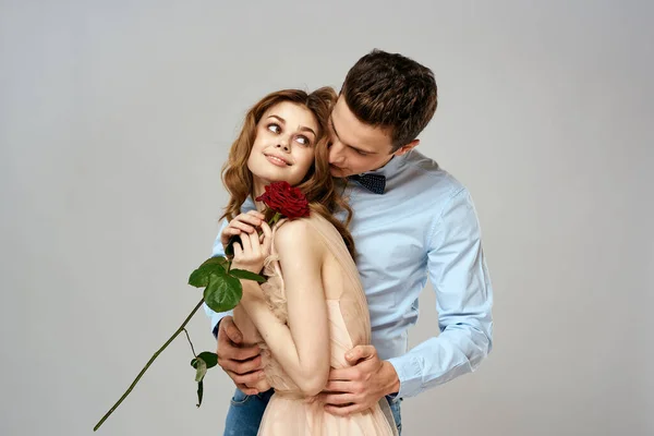 Fröhlich junges Paar Romantik Umarmung Beziehung rote Rose Lifestyle Licht Hintergrund — Stockfoto