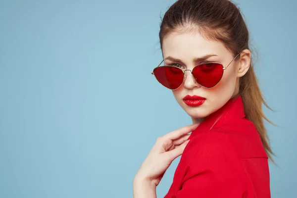 Beautiful woman in dark glasses red shirt bright makeup emotions attractive look blue background — Stock Photo, Image