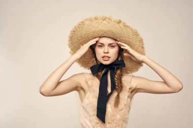 Şapkalı ve arka planda giyinmiş romantik bir kadın elleriyle komik duyguların portresini çiziyor.