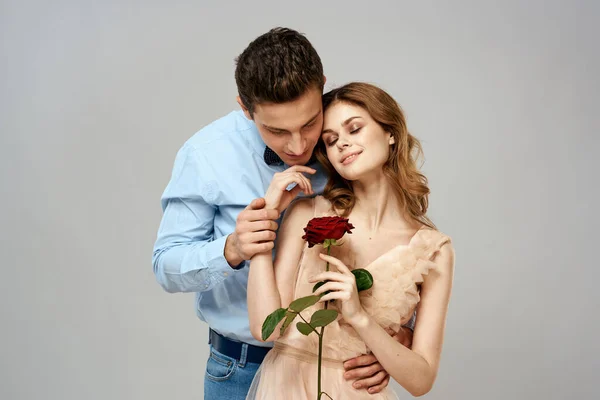 Mladý pár objetí romantiku datování životní styl vztah světlo pozadí červená růže — Stock fotografie