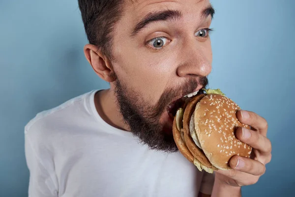 Emotionale Mann Hamburger Fast Food Diät Nahrung Nahaufnahme blauer Hintergrund — Stockfoto