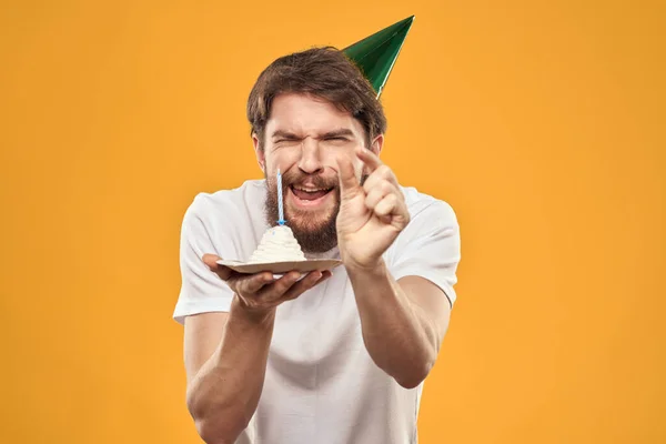 케이크재미있는 노란색 배경 파티 모자를 쓴 생일날의 소년 — 스톡 사진