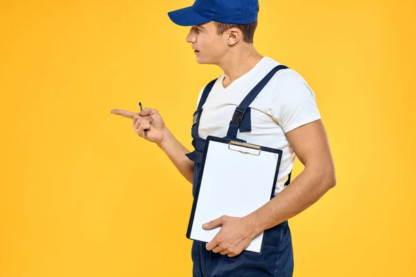 Hombre en documentos uniformes de trabajo prestación de servicios servicio de entrega fondo amarillo — Foto de Stock