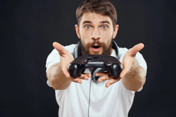 Man met joystick in handen koptelefoon technologie vrijetijdsbesteding spel levensstijl donker geïsoleerde achtergrond — Stockfoto