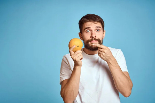 Hombre con naranja sobre fondo azul y vista recortada Copiar Espacio gesto con las manos — Foto de Stock