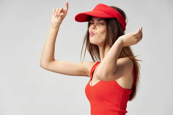 Känslomässig kvinna håller händerna framför sin röda mössa på huvudet T-shirt Livsstil — Stockfoto