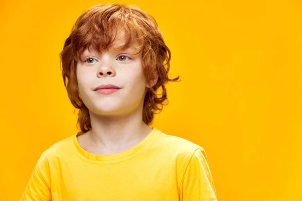 Modo niño feliz se ve a un lado y camiseta amarilla — Foto de Stock