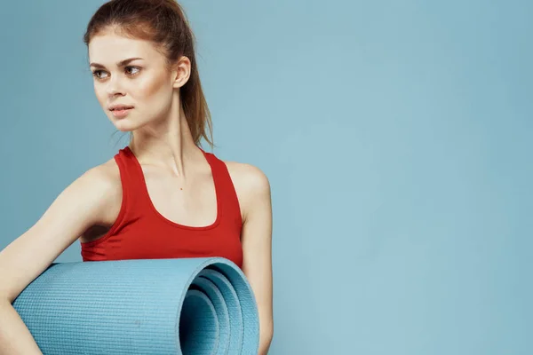 Mujer deportiva en camiseta roja para ejercicios de entrenamiento estilo de vida fondo azul — Foto de Stock
