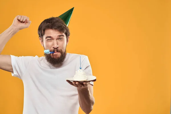Születésnapi fiú egy sapka torta szórakoztató sárga háttér party — Stock Fotó