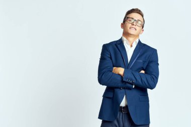 Gözlüklü bir iş adamı mavi takım elbiseli resmi ışık arkaplanı kesmiş.